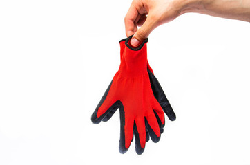 Gloves for workers, construction red with black rubber coating. Black-red gloves. Hand holds, throws out gloves on a white background. Used  gloves