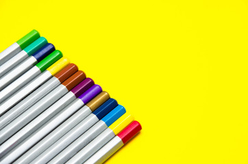 Top of the pencil. Multi-colored pencils in a row on the side and at an angle on a yellow background.  LGBT