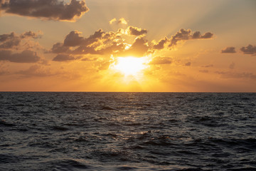 Tramonto rosso sul mar tirreno tra nuvole rosse grandi raggi di sole