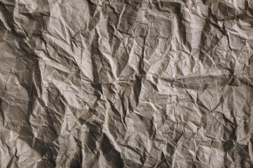 Vintage background from heavily crumpled paper, which is used as a wrapper. The texture of cardboard made from recycled materials.