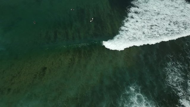 Aerial view from a surfer in the ocean with waves. Drone video