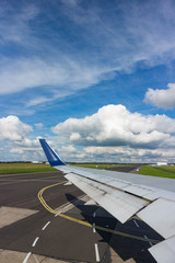 Looking out over Commercial aircraft window airport runway from aircraft taxiing on runway