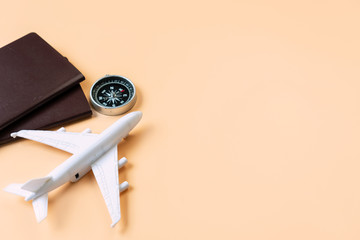 Top view of model plane, passport, compass on orange color background, travel concept. Flat lay , copy space