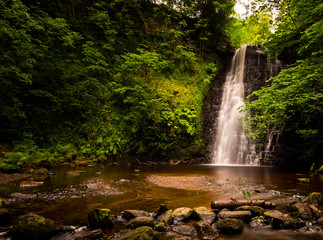 Large cascading waterfall tumbling into a peaceful pool. Falling foss waterfall, Yorkshire Dales 