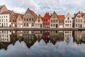 Fototapeta na wymiar Buildings with reflections around channels in Bruges at sunset