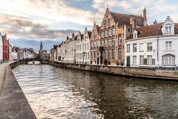 Buildings around channels in Bruges at sunset