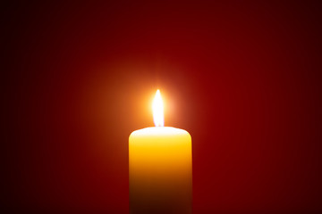 burning candle isolated on red. backgrounds and textures