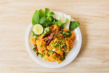 Fermented Pork and Crisp Rice Salad or Yam Naem Khao Tod Recipe,Thai food concept.Top view and wooden background.