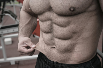 body fat weight loss sport nutrition concept on strong young man with perfect body physique...
