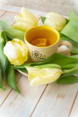 A mug with tea with yellow tulips. Women, mother, valentines day greeting card.