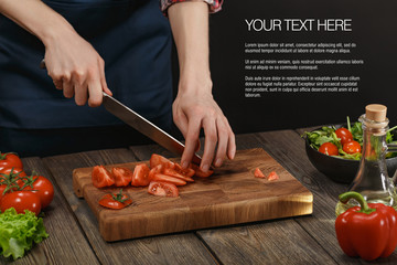 Woman cooking fresh healthy salad. Female hands cutting vegetables on board on wooden table with sample text.