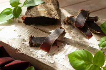 dried roe deer meat on a rustic shabby cutting board
