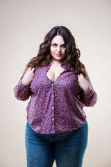 Sexy plus size model in casual clothes, fat woman on beige background