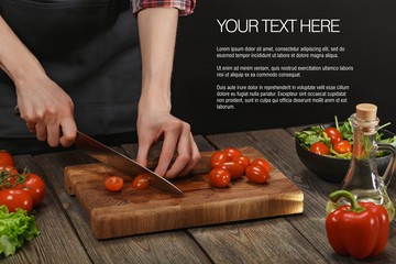 Woman cooking fresh healthy salad. Female hands cutting vegetables on board on wooden table with sample text.