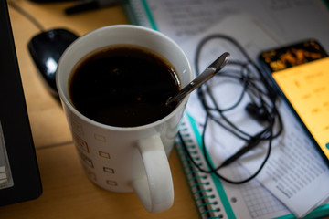 Mug of Coffe at a table with wires and mobile