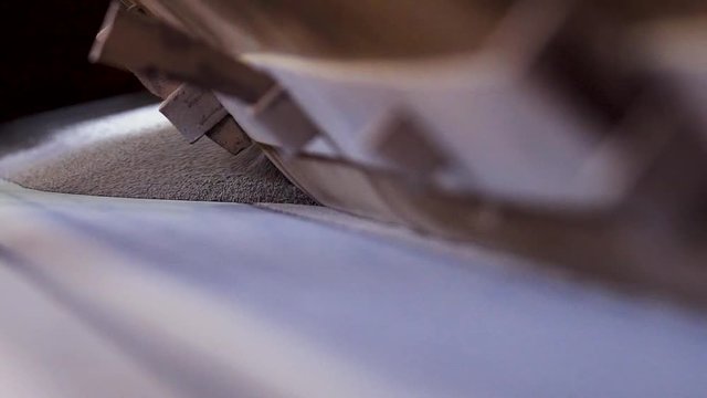 Close-up of bulk material on factory conveyor. Stock footage. Powder raw materials for construction work are poured on conveyor belt of plant