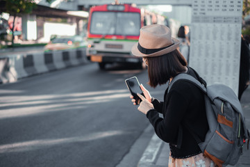 Asian woman tourists to travel. She wears a mask to protect the virus from Covid-19 and Dust pm 2.5 On his holidays. She looked at the travel map and updated the virus spread news.