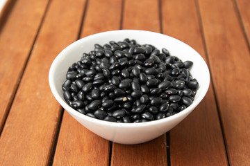 Fototapeta na wymiar Pile of raw Brazilian Black Beans in a bowl. Also know as 'Feijao'