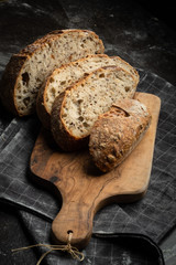 Bread fresh home baking on a wooden board. Black background