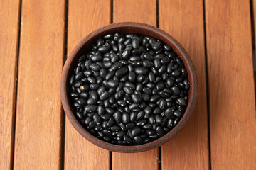 Pile of raw Brazilian Black Beans in a bowl. Also know as 'Feijao'