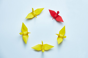 Red origami crane leading group, shallow depth of field