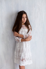 Fototapeta na wymiar portrait of a beautiful fashionable brunette girl in a white pink dress