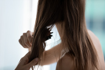 Close up rear view naked woman uses hairbrush combing do morning routine hairs looking damaged dry unhealthy need gentle natural products, deep conditioning, hair loss treatment care medicine concept