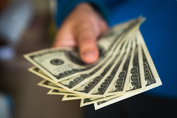 Hand with money. Hand holding us dollar bills. Hands with money isolated on a black background. American dollar bills being held out.