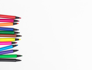 Obraz premium Colorful marker pen set messily placed on white background.
