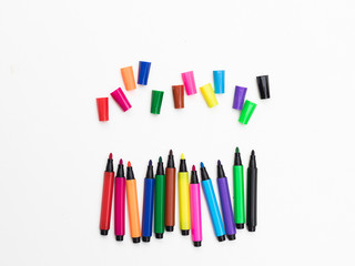 Colorful marker pen set and pen caps on white background.