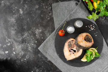 Wild sturgeon steak on a black slate Board on a black kitchen table. Healthy seafood. Top view with space for text	
