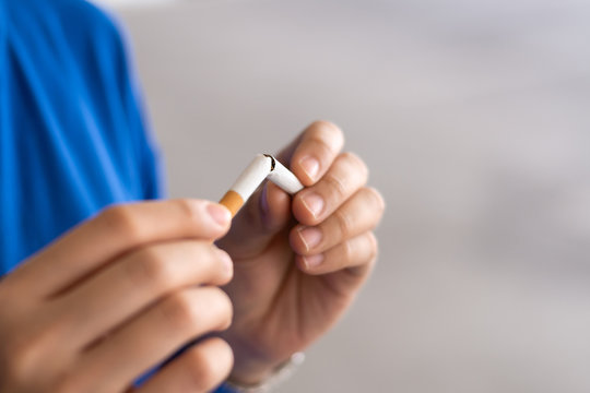 Woman hands holding and breaking the cigarette for quit smoking. Stop smoking cigaratte for health concept.