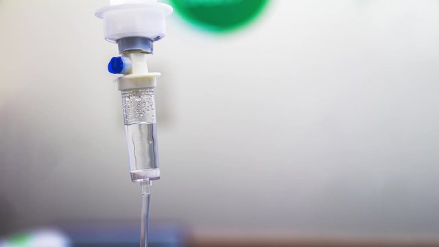 Cinemagraph of a fluid intravenous saline drip in a hospital room. Close up on Set IV fluid intravenous drop saline on a white background. Loop, selective focus, and copy space.