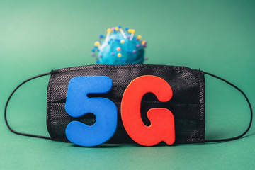Symbol of coronavirus and 5g network next to a medical mask. The effect of 5g networks on coronavirus