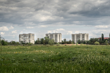 Fototapeta na wymiar Old Soviet socialist prefabricated apartment buildings in the summer afternoon in the field.