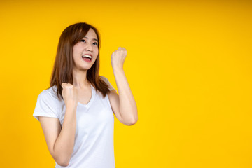 Young elegant Asian woman smiling and expressing a very happy isolated on yellow background