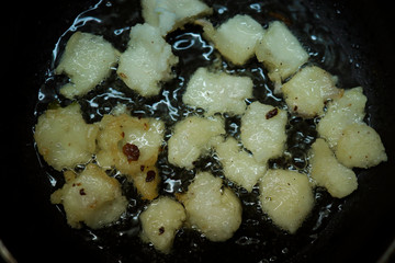 Onion vada with hot oil boiling in cooking pan closeup view, Indian dish making in a traditional home method , some area this is called ulli vada.