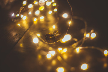 two golden rings on top of each other lit by xmas lights