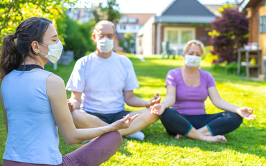 Group session of yoga with face masks - meditation lesson in a nursing home during or after corona...