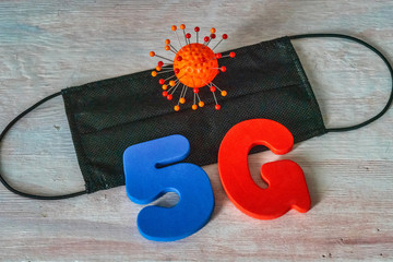 Symbol of coronavirus and 5g network next to a medical mask. The effect of 5g networks on coronavirus