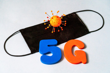 Symbol of coronavirus and 5g network next to a medical mask. The effect of 5g networks on coronavirus