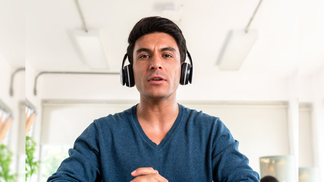 Scene of caucasian man wear headphone attend an online meeting while stay at home