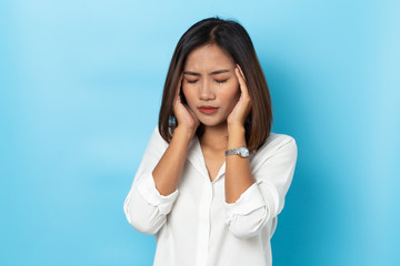 asian young woman having headache on blue background