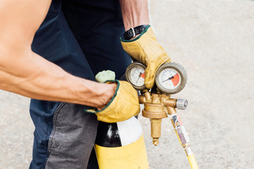 compressed air bottle and pressure gauge held by firefighter with gloves