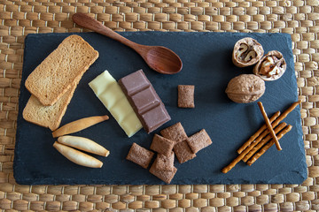 Pan y chocolate sobre plato de pizarra y mantel de mimbre hecho a mano.