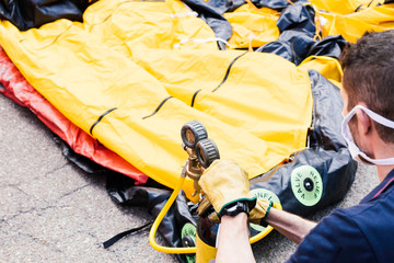 Firefighter inflates decontamination tunnel for covid 19 by compressed air bottle