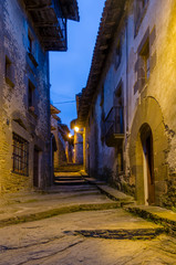 Callejuela del pueblo medieval de Rupit iluminado al anochecer (Cataluña, España).