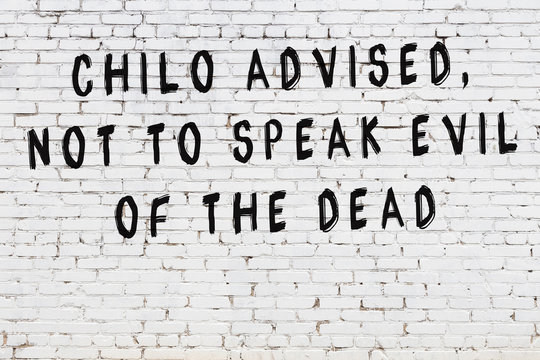 White brick wall with painted black inscription of wise quote