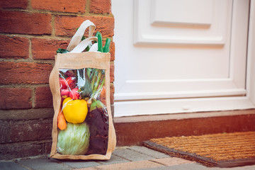 Fresh organic vegetable delivery concept. Reusable bio eco sackcloth fabric bag packaging near...