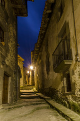 Fototapeta na wymiar Callejuela del pueblo medieval de Rupit iluminado al anochecer (Cataluña, España).